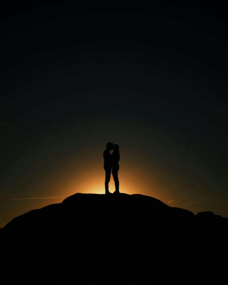 Ombre d'un couple qui s'étreint avec le soleil qui se couche en arrière plan