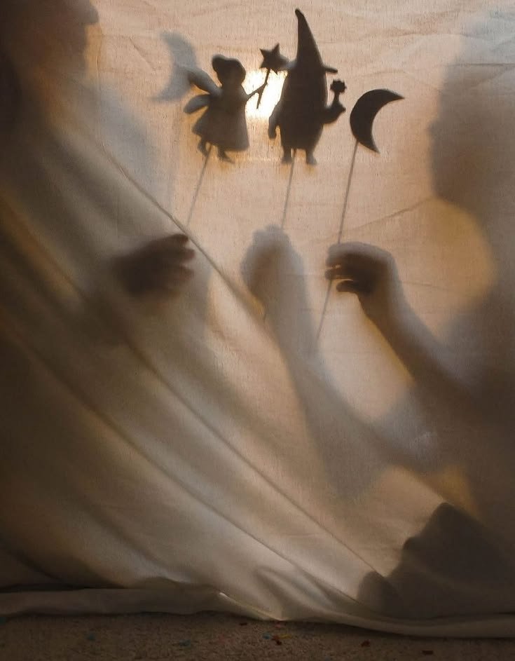 Ombres chinoises d'enfants jouant avec des marionnettes en forme de fée, d'étoile et de croissant de lune