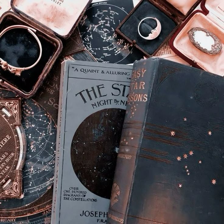 Carnets d’astrologie bleu nuit et blanc à motifs dorés, bougie allumée et quartz brut