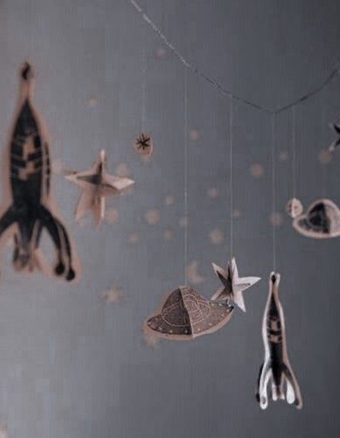 Mobile suspendu représentant une fusée, des étoiles et des planètes dans une chambre d'enfant