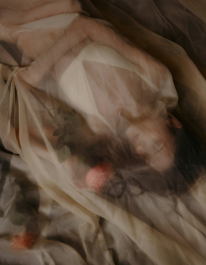 Femme sous un drap en transparence avec des roses