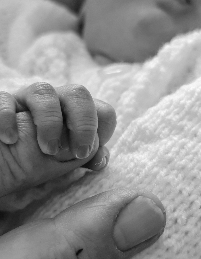 Alt="Main de nouveau né qui tien l'index d'un de ses parents pour illustrer la couverture d'un article de blog"