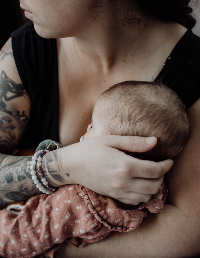 Alt="Photographie d'Anaïs fondatrice de Celeste Ceremonia tenant sa fille endormie dans ses bras utilisée pour illustrer un article du blog"