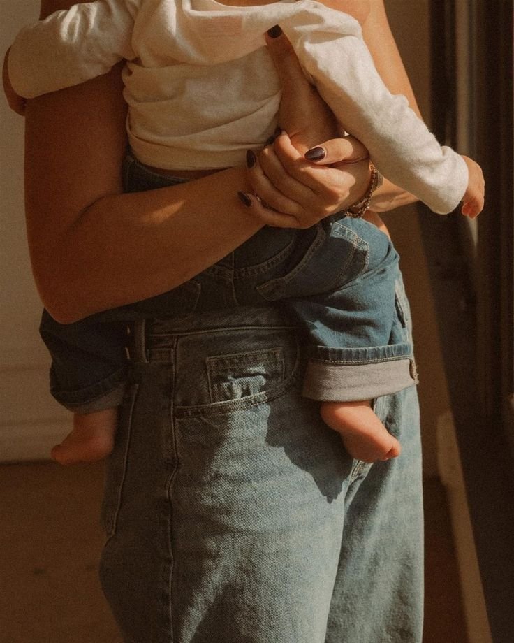 mère portant son enfant vue des deux pantalons en jean