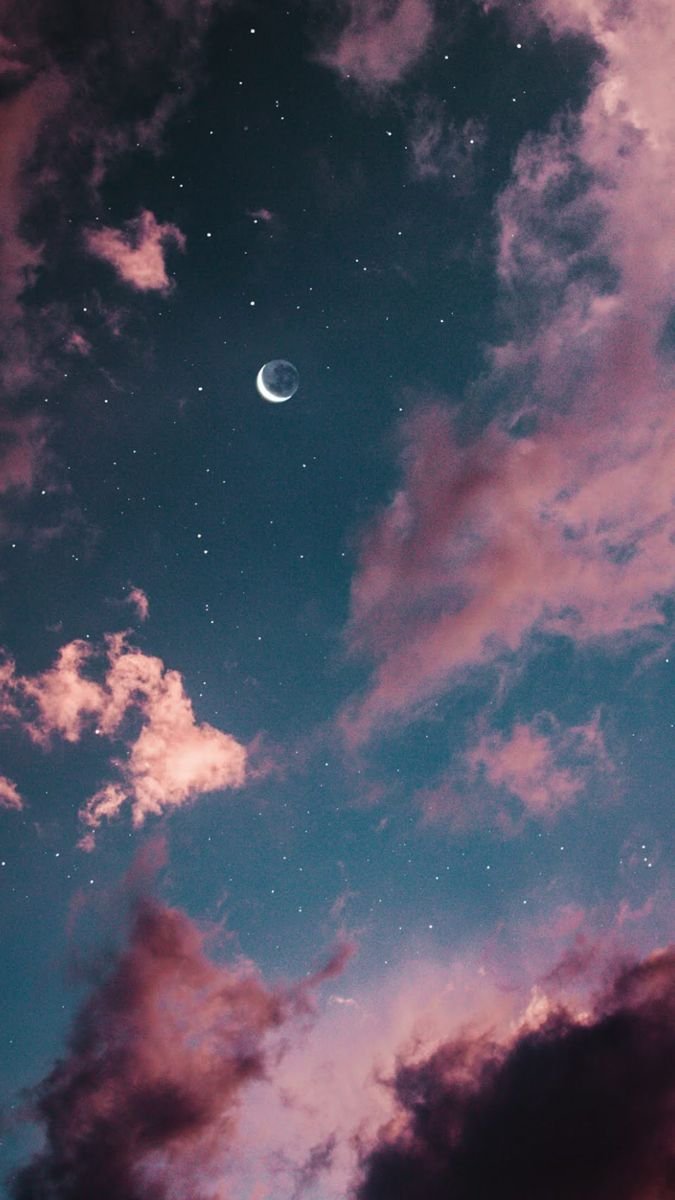 croissant de lune sur fond de ciel étoilé et nuages rosés