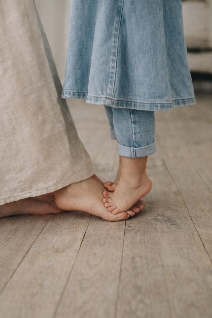 Pieds d'enfant sur les pieds de sa mère
